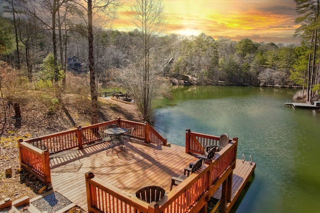 view of dock featuring a water view and a forest view