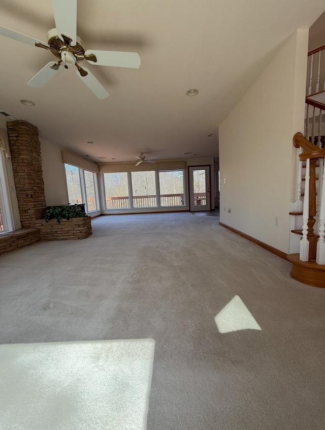 unfurnished living room with stairway, carpet, baseboards, and a ceiling fan