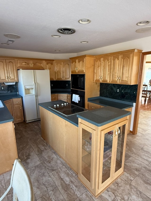 kitchen with visible vents, dark countertops, black appliances, decorative backsplash, and a kitchen island