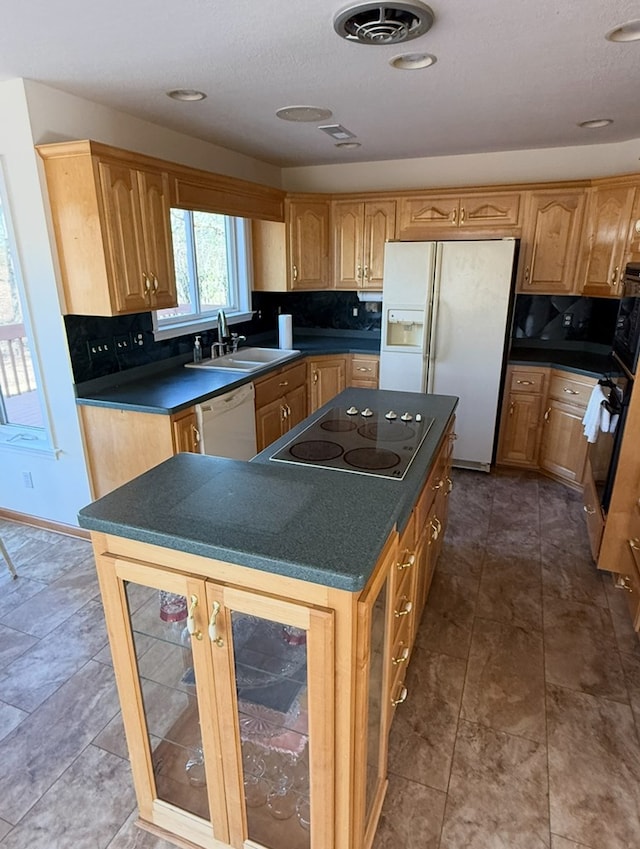 kitchen featuring white appliances, dark countertops, visible vents, decorative backsplash, and a sink