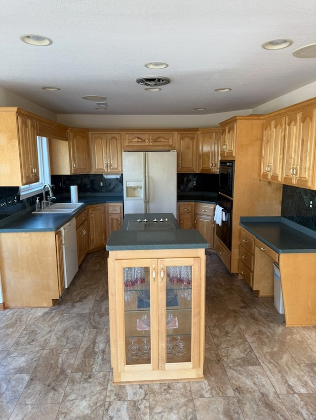 kitchen with a center island, a sink, dark countertops, black appliances, and decorative backsplash