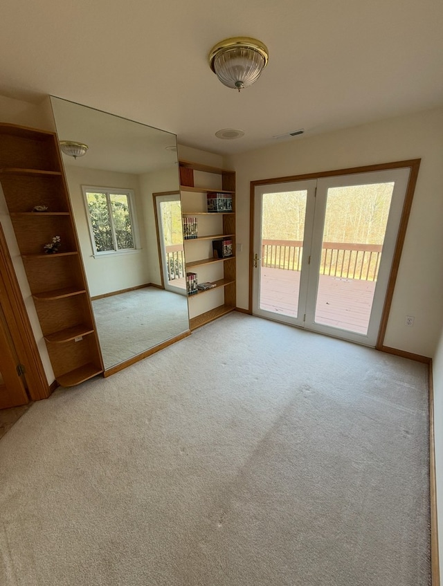 unfurnished room featuring light carpet, visible vents, and baseboards
