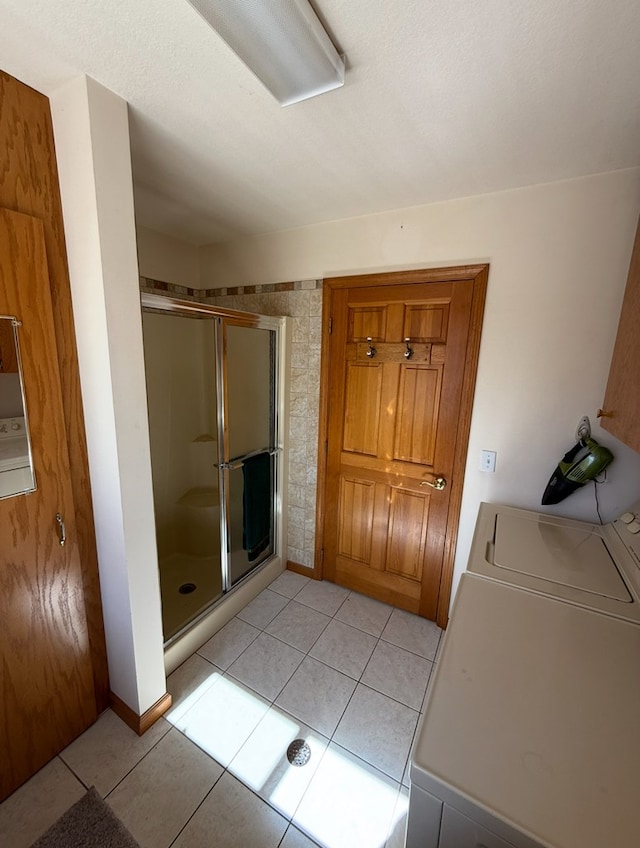 bathroom with a shower stall, tile patterned floors, and washer and clothes dryer