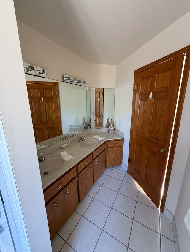 full bath with tile patterned floors, double vanity, and a sink