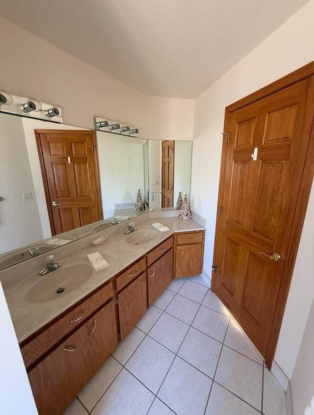 full bathroom featuring a sink, double vanity, and tile patterned flooring