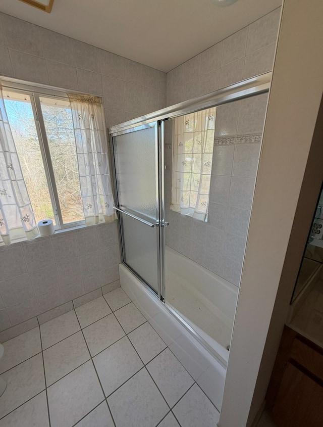 bathroom featuring combined bath / shower with glass door and tile patterned flooring