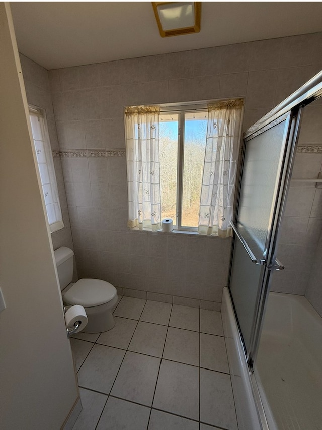 full bathroom with toilet, tile walls, and tile patterned flooring