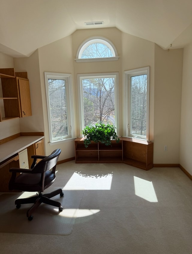 office area featuring visible vents, baseboards, vaulted ceiling, and light carpet