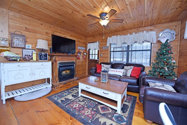 living room with light hardwood / wood-style flooring, ceiling fan, wood walls, and wood ceiling