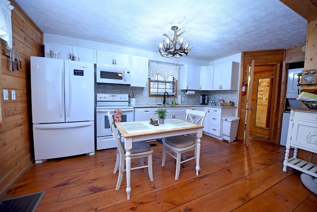 kitchen featuring white cabinets, white appliances, and decorative light fixtures