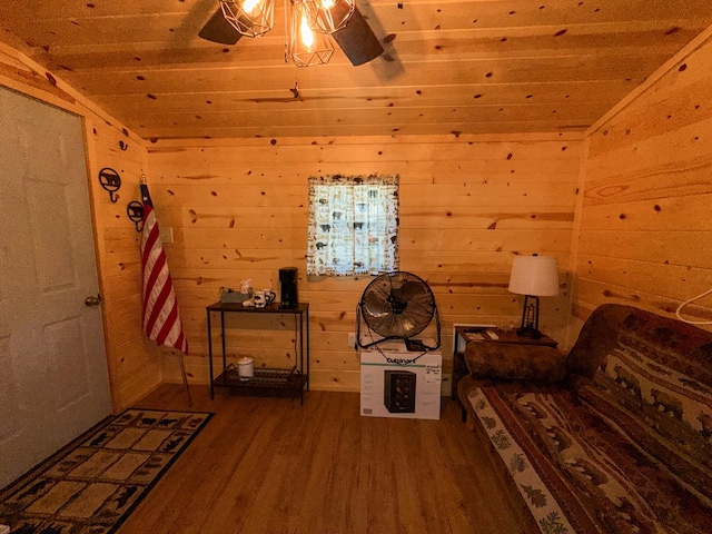 living area with lofted ceiling, wooden walls, hardwood / wood-style flooring, and wood ceiling