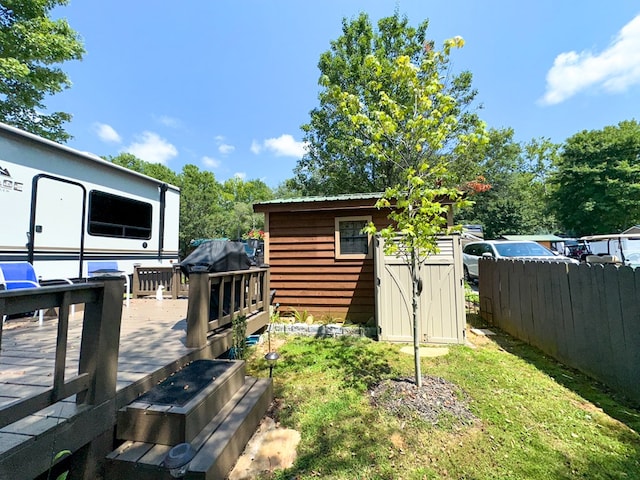 view of yard with a deck and a storage shed