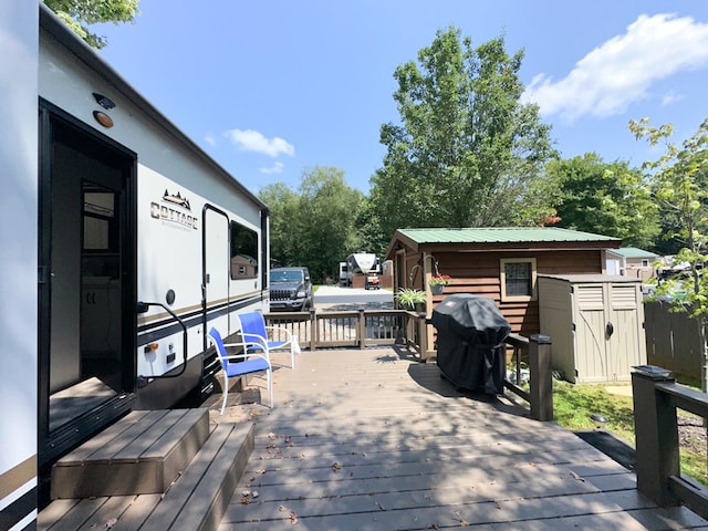 wooden deck with grilling area and a storage shed