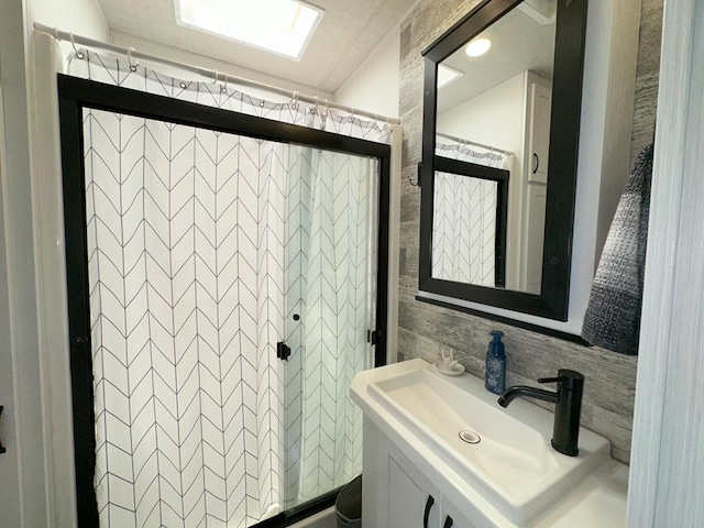 bathroom featuring vanity, decorative backsplash, and a shower