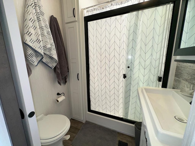 bathroom with toilet, a shower with door, wood-type flooring, and sink