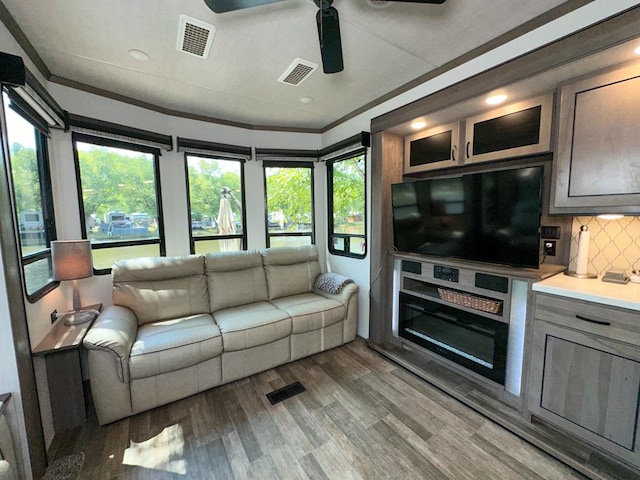 living room with ceiling fan, hardwood / wood-style floors, and ornamental molding