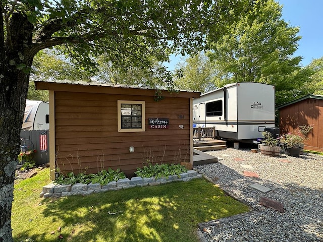 view of property exterior featuring a lawn and an outdoor structure