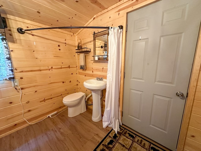 bathroom with hardwood / wood-style floors, wooden ceiling, vaulted ceiling, toilet, and wooden walls