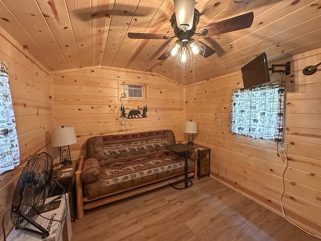 living area with wood ceiling, hardwood / wood-style floors, ceiling fan, wooden walls, and lofted ceiling