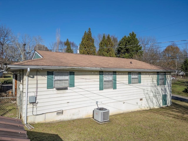 view of side of property featuring a yard and central AC