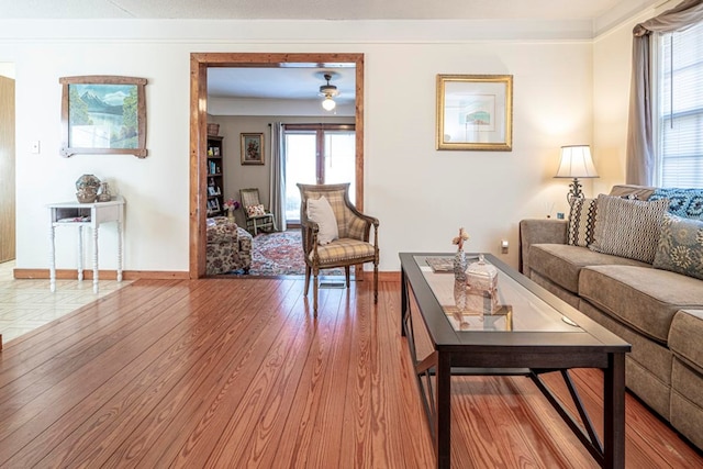 living room with crown molding, ceiling fan, light hardwood / wood-style flooring, and a healthy amount of sunlight