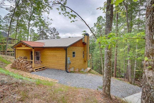 view of side of home with a chimney and metal roof