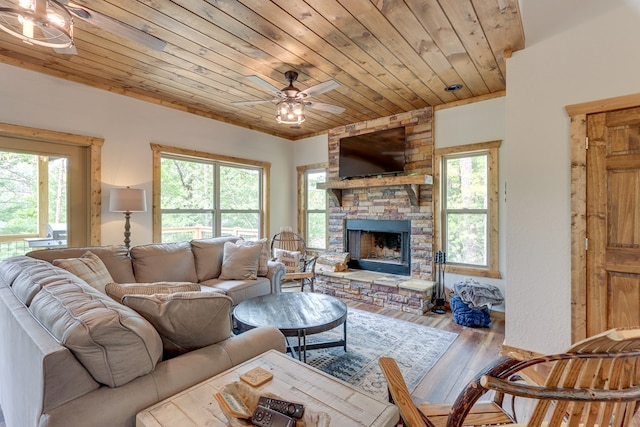 living area featuring wood ceiling, a fireplace, a ceiling fan, and wood finished floors