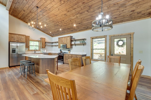 dining area with high vaulted ceiling, light wood-style flooring, wood ceiling, and a notable chandelier