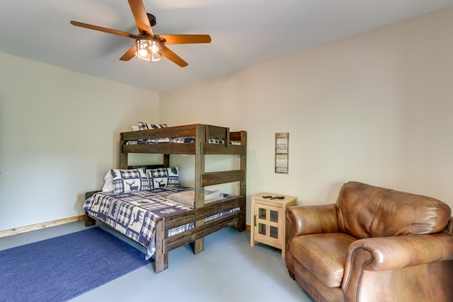 bedroom featuring concrete flooring and baseboards