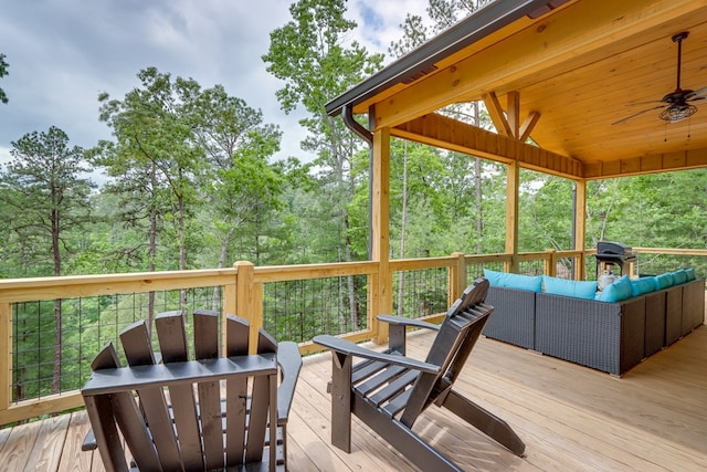 wooden deck with ceiling fan and an outdoor living space