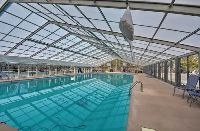 community pool with glass enclosure and a patio