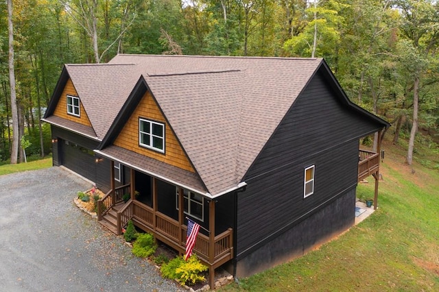 view of side of property with a garage and covered porch