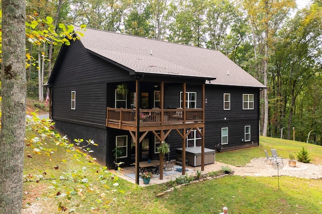 back of house with a wooden deck, a yard, and a patio area