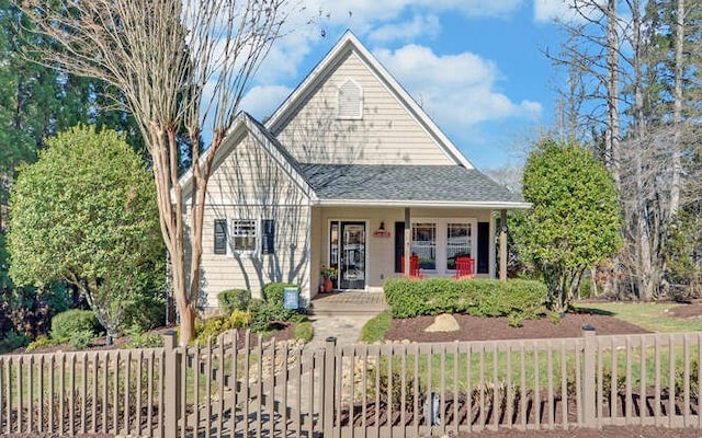 view of front of property featuring a fenced front yard and roof with shingles