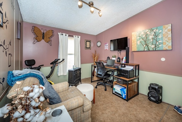 carpeted home office featuring a textured ceiling