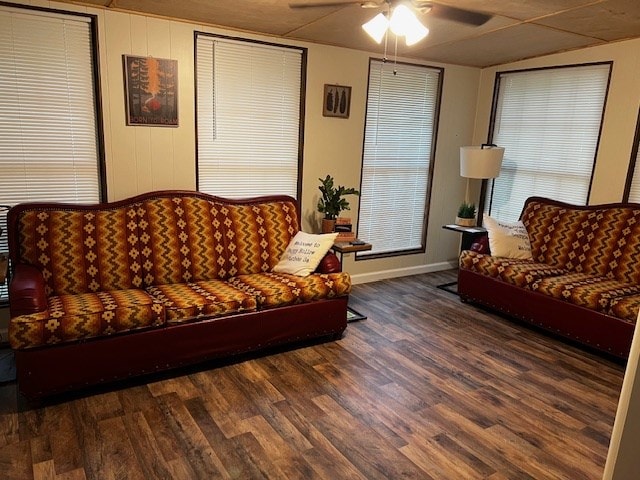 living room with dark wood-type flooring and ceiling fan