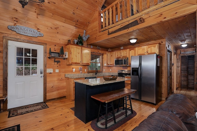 kitchen featuring wooden ceiling, wood walls, appliances with stainless steel finishes, light wood-type flooring, and a center island