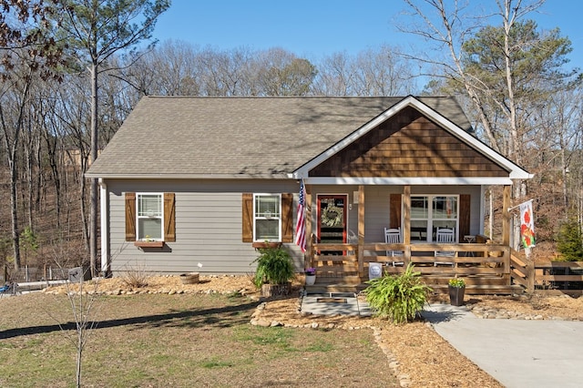 view of front facade with covered porch and roof with shingles