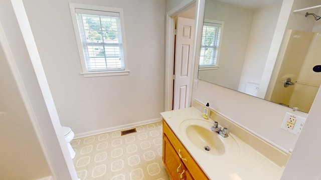 bathroom featuring vanity, toilet, a shower, and tile patterned floors