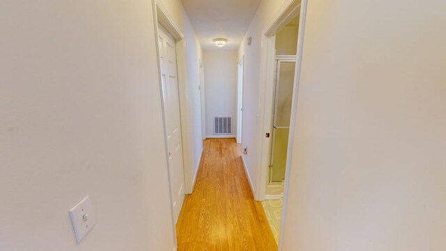 hallway with light hardwood / wood-style flooring