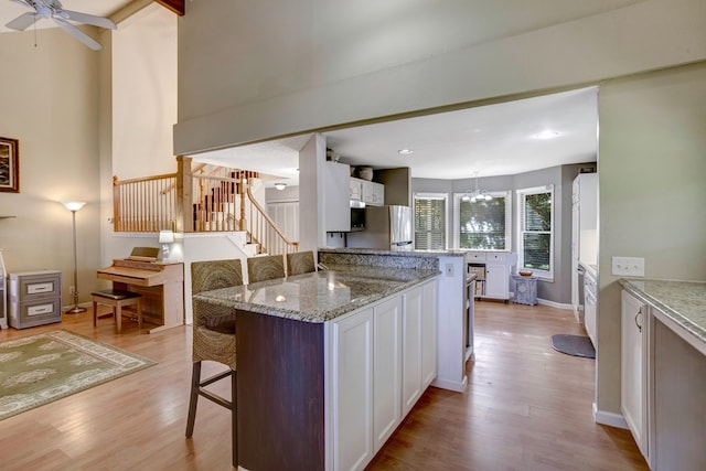 14 Rivendell Dr, Hayesville, NC 28904 - kitchen with a kitchen breakfast bar, appliances with stainless steel finishes, light wood finished floors, white cabinetry, and recessed lighting