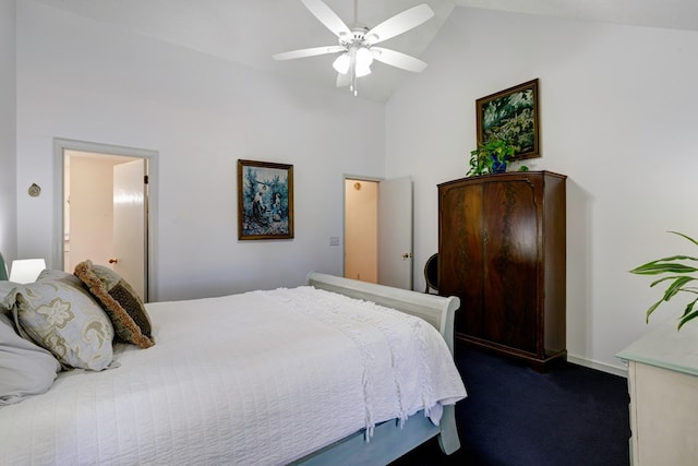 bedroom with dark colored carpet, ceiling fan, high vaulted ceiling, and connected bathroom