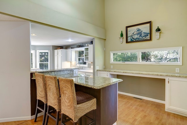 14 Rivendell Dr, Hayesville, NC 28904 - kitchen with white cabinets, light wood finished floors, a breakfast bar, and recessed lighting