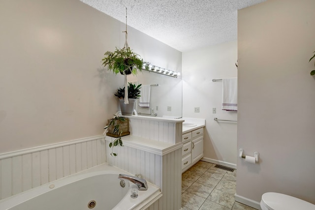 bathroom featuring vanity, a bath, tile patterned flooring, toilet, and a textured ceiling