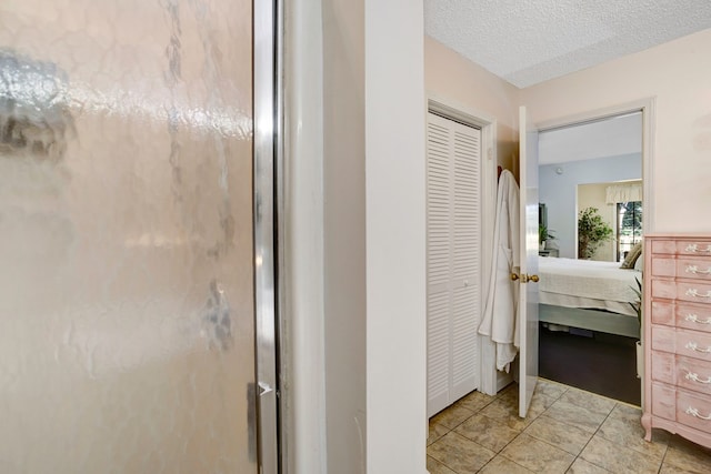 bathroom with tile patterned flooring and a textured ceiling