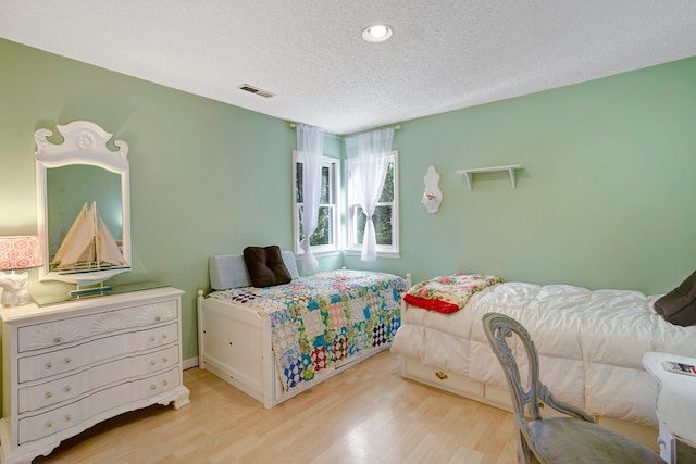 bedroom featuring a textured ceiling and light wood-type flooring