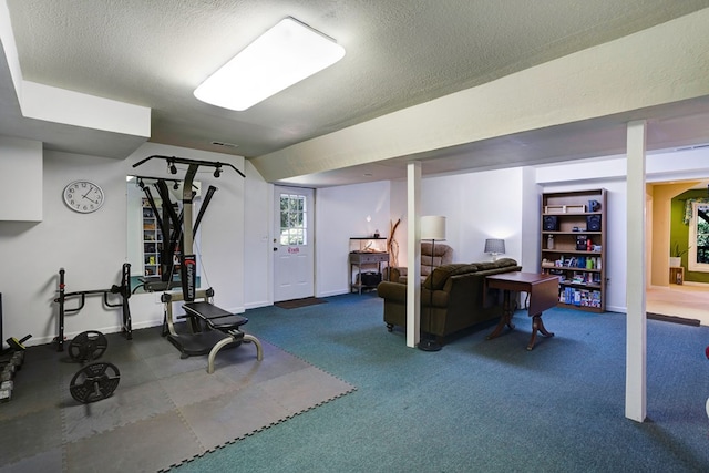 exercise room with carpet and a textured ceiling