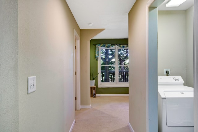 corridor featuring washer / dryer and light colored carpet