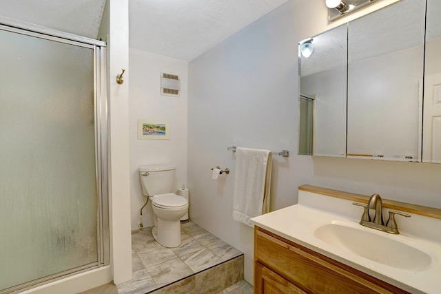 bathroom with a textured ceiling, vanity, an enclosed shower, and toilet