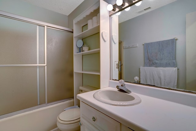 full bathroom featuring combined bath / shower with glass door, a textured ceiling, vanity, and toilet